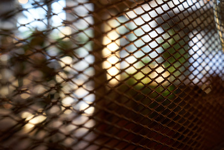Abstract blurred cafe bar restaurant interior background through the wire mesh fence, close-up.