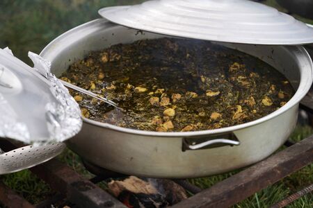 Pilaf cooking on fire outdoor. Open air kitchen at party. Open pot with rice and meatの写真素材