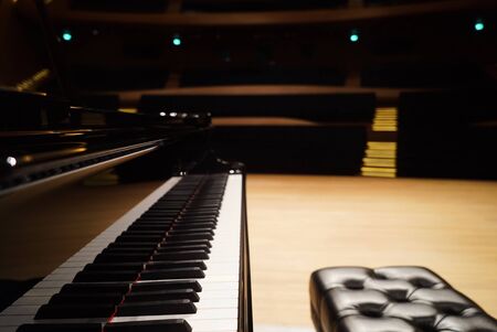 Grand Piano and seat in Concert Hall, close-up. Piano key at concert stageの写真素材