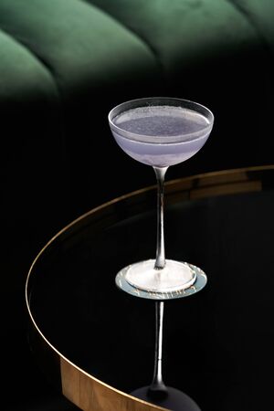 Fresh cocktail glass on glass table in night club restaurant. Alcohol cocktail drink, close-up. Retro alcoholic beverageの写真素材