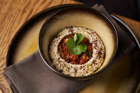Baba ganoush hummus with eggplant on wooden table background. Traditional Middle Eastern cuisine, vegan aubergine hummus with pita bread toasts, close-up.の写真素材