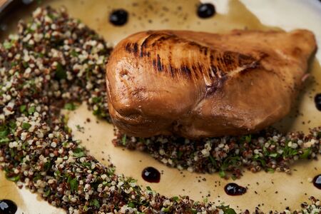 Roasted chicken breast on plate on wooden table background. Fried chicken fillet breast, close-up.