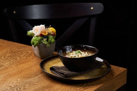 Spinach pasta salad with cheese, paprika, chicken, parsley.Green spinach pasta with cheese on wooden table background, close-up. Luxury restaurant food. Gourmet italian mealの写真素材