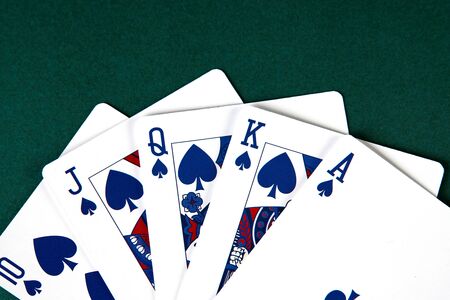 Poker cards on green background with copy space. Winning combination of cards Royal flush on casino...