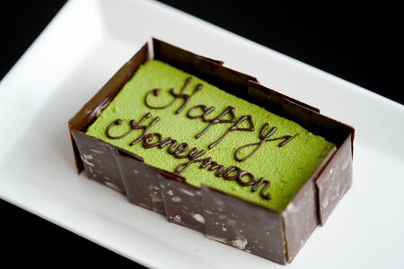 Happy honeymoon cake piece, close-up. Honeymoon cake on a white plateの写真素材