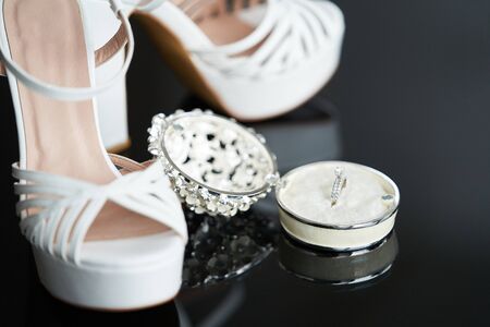 Bride Wedding accessories. Bride wedding set with shoes and engagement rings, close-up.の写真素材