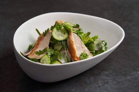 Farm chicken salad romaine lettuce and tarragon pesto. Healthy fresh chicken breast salad with radish, cucumber and herbs, close-upの写真素材