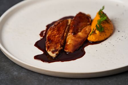 Sous vide chicken breast with mashed young carrots and chicken jus, close-upの写真素材