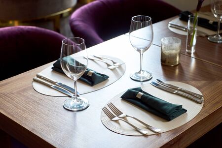 Restaurant table setting with Empty clean glasses. Banquet dining table serving with dishes, wine...