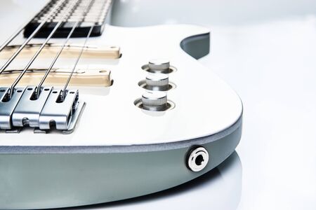 White Electric Bass Guitar strings, close-up. White bass guitar details on a white background with...