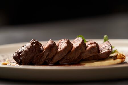 Filet mignon with mashed potatoes and pomegranate sauce. Filet mignon Steak with red wine sauce on white plate on gray background with copy space, close-upの写真素材