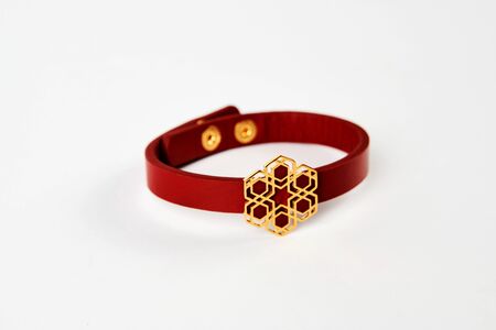 Red leather and gold cuff bracelet on white background with copy space. Female precious bracelet with gemstone jewelry, close-up. Bangle jewelryの写真素材