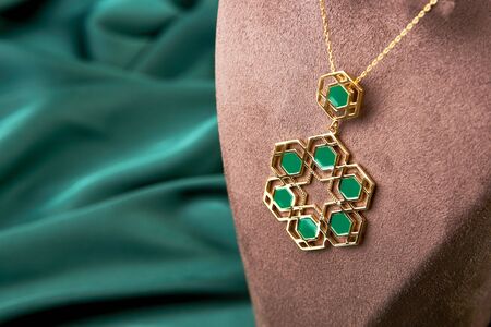 Gold necklace with jewelry pendant on black background. Golden chain with precious pendant, close-up. Luxury female jewelryの写真素材