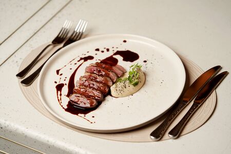 Mashed potato and grilled duck breast, close-up. Luxury restaurant dinner with potato garnish and...