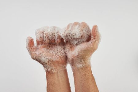 Man washing dirty hands with soap, close-up. Soapy male hands isolated on white background with copy space.  Hand washing medical procedure step. Personal hygieneの写真素材
