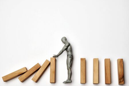 Stop COVID-19 Pandemic Coronavirus concept. Toy human stops fall of dominoes represents pandemic...