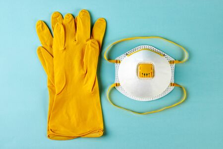 Latex medical gloves and surgical mask on blue