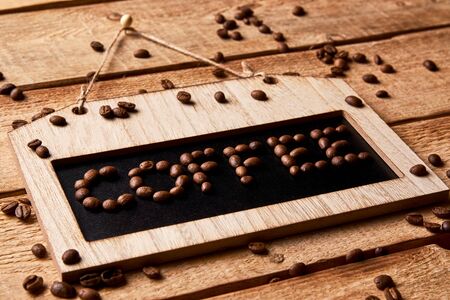 Coffee shop chalkboard frame. Blackboard with COFFEE text by coffee beans on wooden wall background. Hanging door sign boardの写真素材