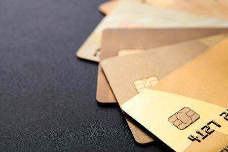 Gold credit cards on black background with copy space. Stack of credit cards, close-up, Selective focus.の写真素材