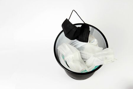 Used medical masks in waste trash bin.