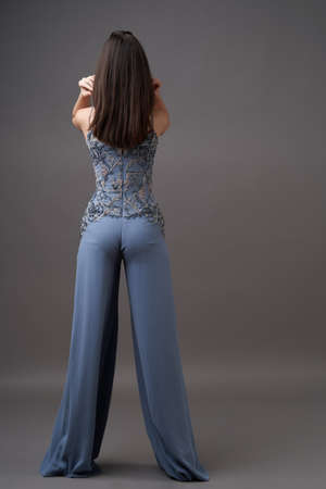 Portrait of a beautiful woman in trendy bodysuit trousers. Young brunette woman, fashion model...