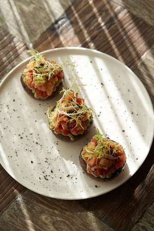 Hummus with avocado and herbs. White plate with hummus and pancakes on tableの写真素材