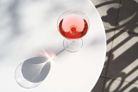 Red cocktail in martini glass with cherry. Exotic alcoholic cocktail on tableの写真素材