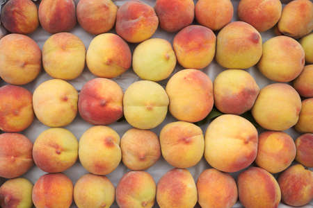 Freshly harvested peach background. Ripe peach stacked, top view, close-upの写真素材
