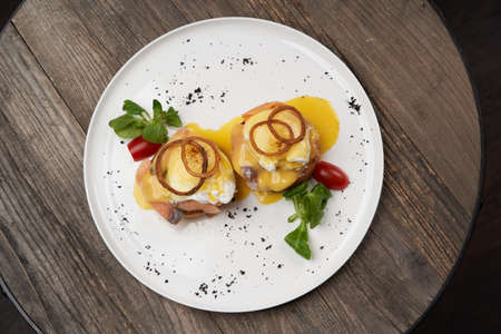 Eggs Benedict with smoked salmon, poached eggs. Classic breakfast table with toast, avocado, poached eggsの写真素材