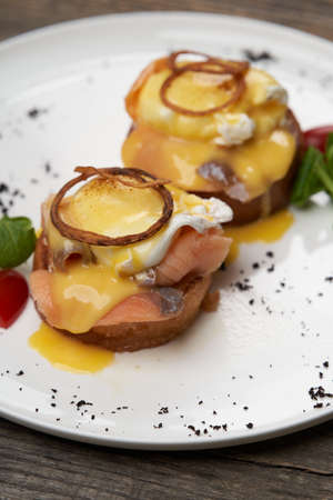 Eggs Benedict with smoked salmon, poached eggs. Classic breakfast table with toast, avocado, poached eggsの写真素材