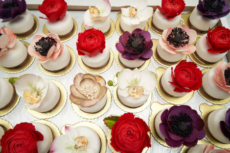Flower cakes background. Birthday cupcakes with flowers. Colorful cupcakes decoration