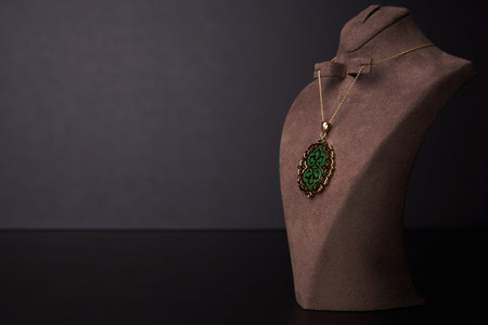 Gold necklace on black background. Jewelry chain with gold pendant. Luxury female jewelryの写真素材