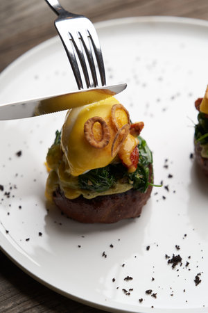 Eggs Benedict with vegetables. Poached egg toast with guacamole sauce and spinach leaves. Vegetarian...