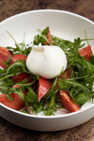 Mozzarella burrata salad with shrimp, arugula leaves and tomatoes. Healthy salad with traditional italian burrata cheeseの写真素材