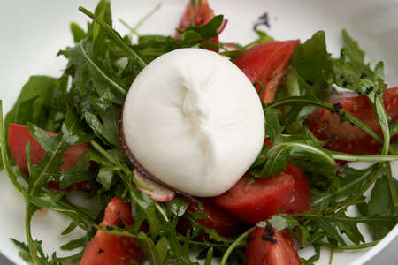 Mozzarella burrata salad with shrimp, arugula leaves and tomatoes. Healthy salad with traditional italian burrata cheeseの写真素材