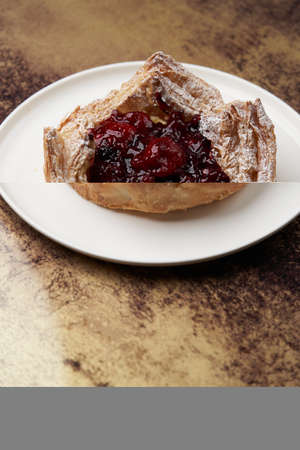 Puff pastry cake with berries on wooden background. Delicious pastries with cherry jam and...