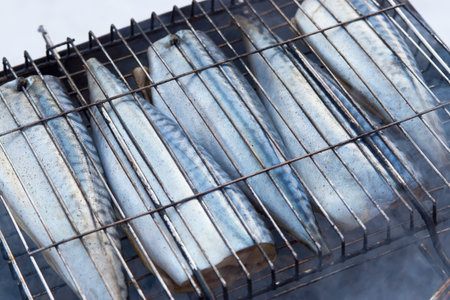 Mackerel fish on a grill, close-up. Grilled mackerel fish on bbq at winter day, outdoorの写真素材
