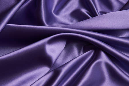 Purple silk fabric background, close-up. Smooth violet satin cloth texture can use as abstract background with copy spaceの写真素材