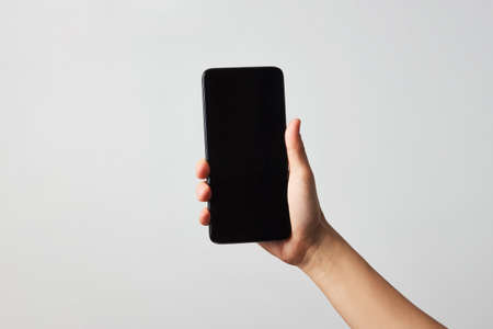 Woman hand holding phone on white background with copy spaceの写真素材