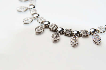 Elegant necklace with diamonds on white background with copy space. Women's platinum necklace with a precious gemstones, close-up. Elegant female jewelryの写真素材