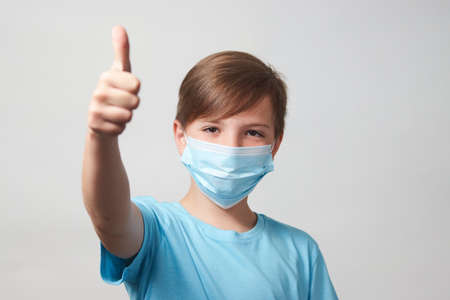 School boy with face mask on white background with copy space, close up. Portrait of child boy in face maskの写真素材