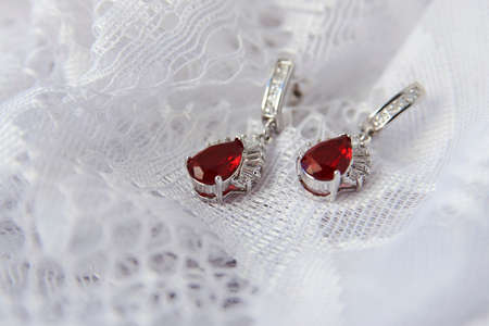 Ruby diamond earrings on white background. Diamond earrings with ruby gemstone, close-upの写真素材