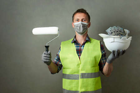 Construction worker with a hard hat full of dollar money. Industrial worker salary conceptの写真素材