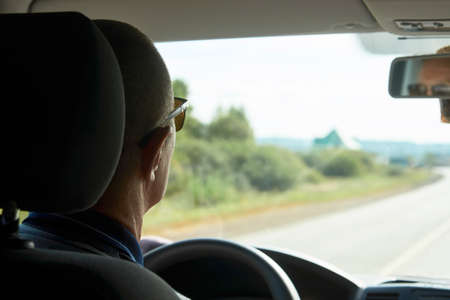 Man driving car, close-up. Driver hands holding steering wheel of a car.の写真素材