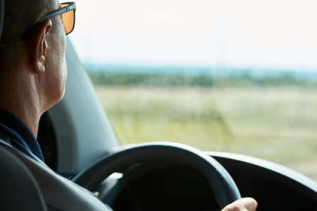 Man driving car, close-up. Driver hands holding steering wheel of a car.の写真素材