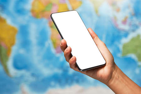 Woman holding smartphone with white screen. Woman hand holding phone on blue map background with...