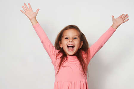 Portrait of cute happy child girl against white background with copy space, close-up. Little girl...