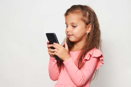 Little child girl brushing her teeth on white background. Beautiful girl with toothbrush, healthy...