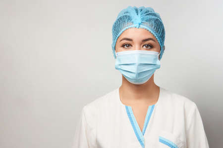 Portrait of young asian doctor in medical mask. Young beautiful woman doctor in a mask and gloves. Covid 19, coronavirus, healthcare conceptの写真素材