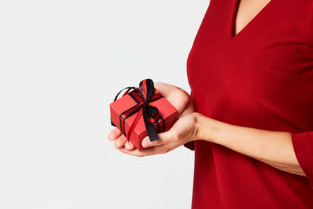 Woman hands holding small gift box with ribbon on white background. Christmas, New Year, Valentine's day and birthday conceptの写真素材